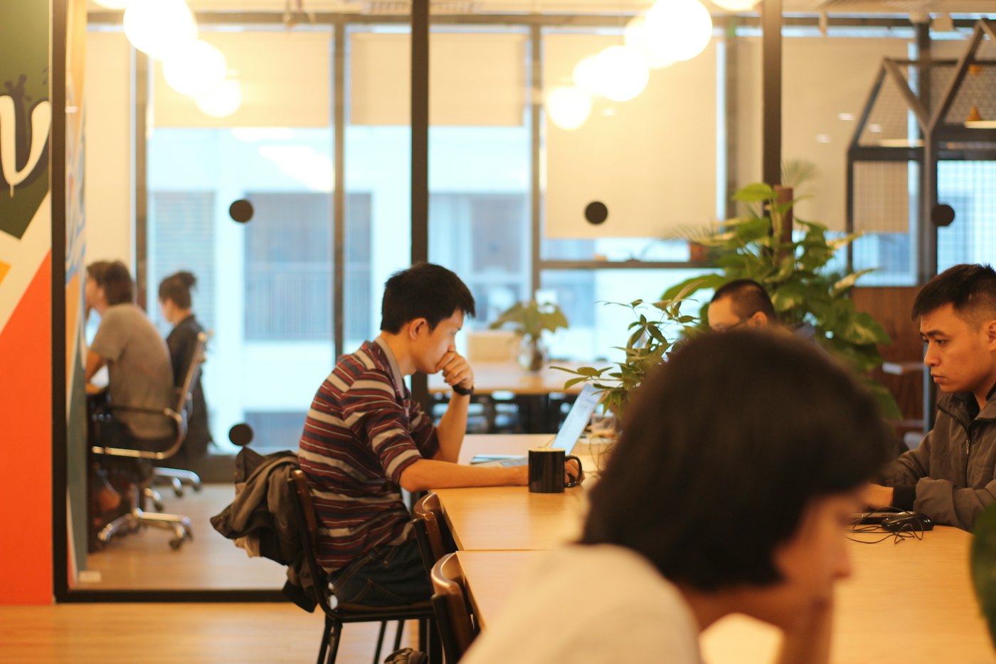 Personas trabajando concentradas en mesas de una planta de oficinas